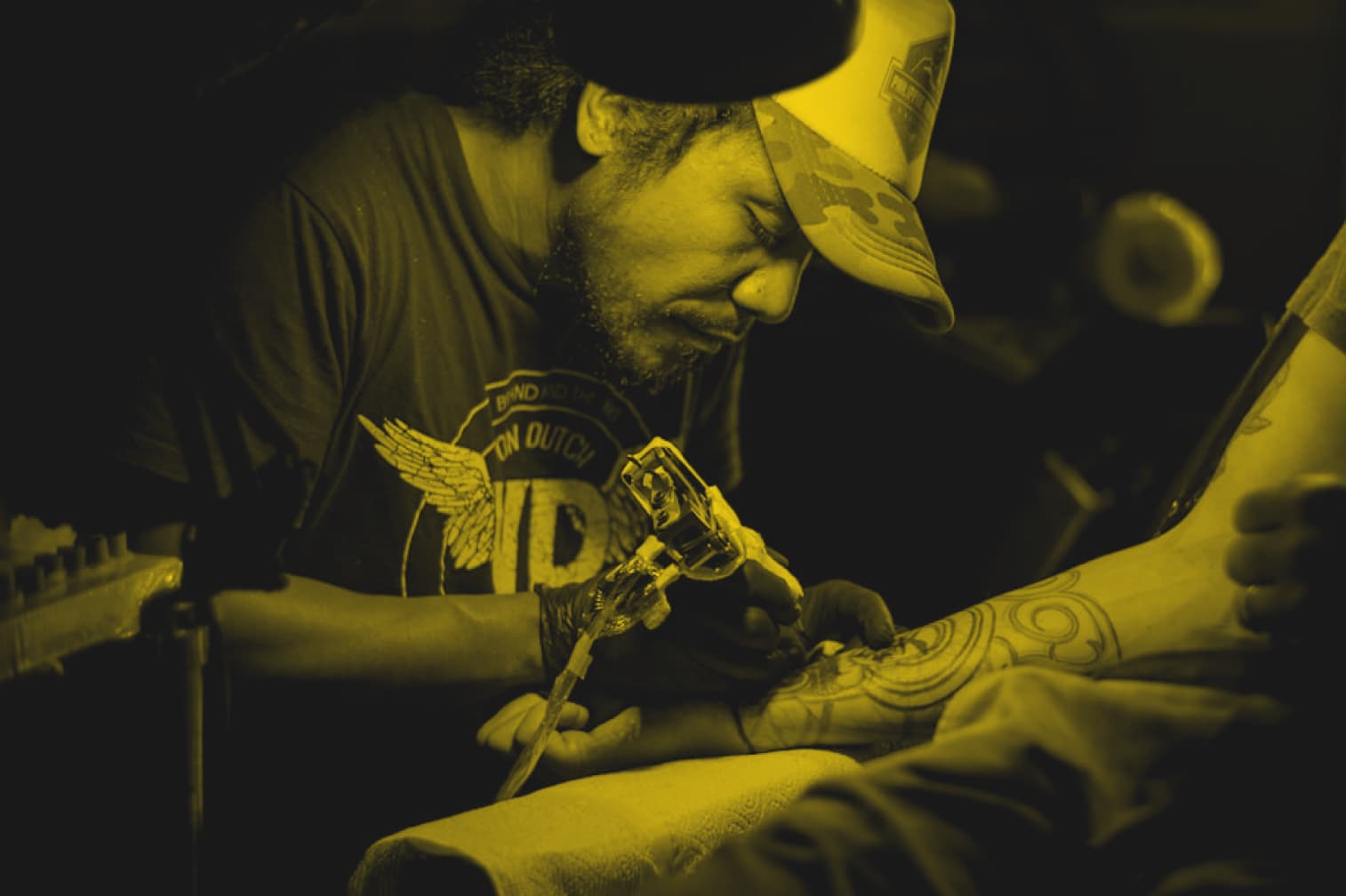Tatuador tatuando um braço